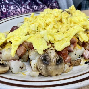 a plate of eggs, sausage, and mushrooms