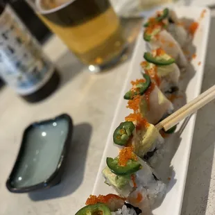 a sushi roll and a glass of beer