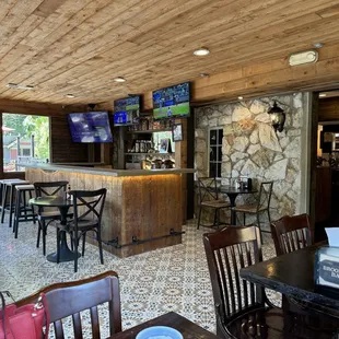 The decor of Brooke Street Bar-B-Q appears to have a rustic and cozy vibe. The wooden ceiling and bar add a warm, inviting feel,