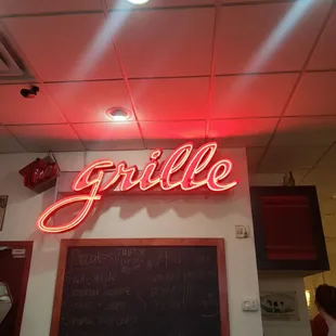 a neon sign above a chalkboard