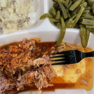 BBQ drenched in vinegar concoction with overcooked green beans.