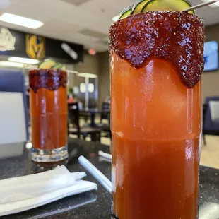 a bloody drink with a cucumber garnish