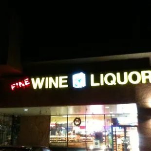 the front of a liquor shop at night