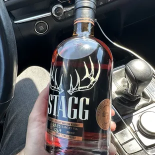 a hand holding a bottle of booze