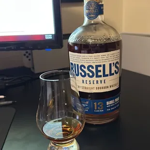 a glass and a bottle on a desk