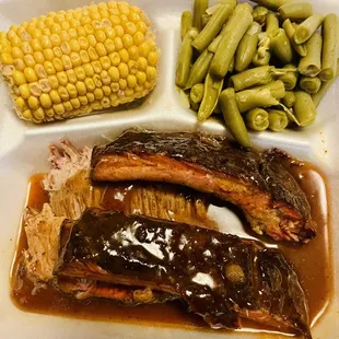 e shows a tray of ribs, green beans, and corn