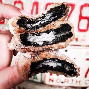 a hand holding a half eaten donut