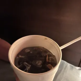 a person holding a cup of ice tea