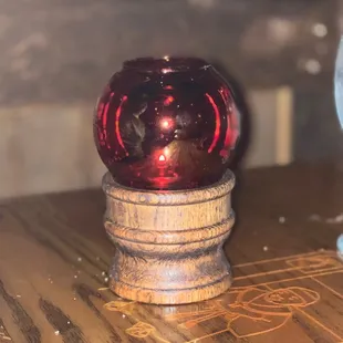 a red glass ball on a wooden table