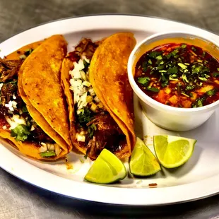 Two Birria tacos with a side of consome