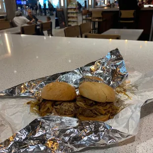 two sandwiches wrapped in tin foil