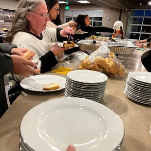 a group of people at a table with plates of food