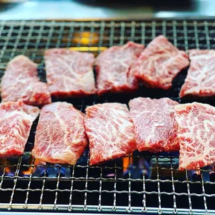 steaks cooking on a grill