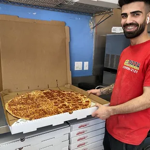  man holding a box of pizza