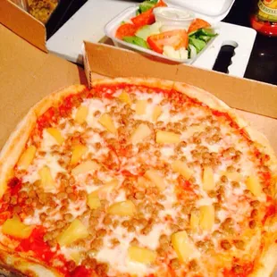 Beef sausage and pineapple pizza with a side salad.