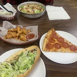 two plates of pizza and a sandwich