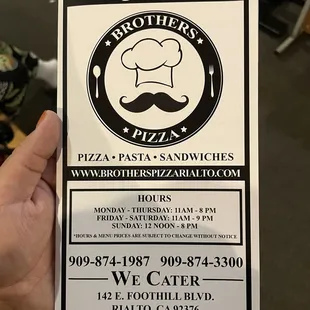 a hand holding a menu