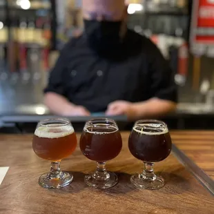 three glasses of beer on a bar