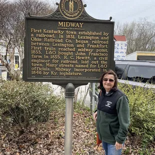a woman standing in front of a sign
