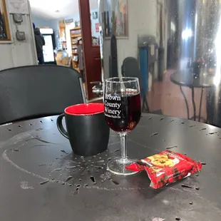 a glass of red wine and a snack on a table