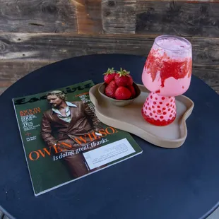 a drink and a magazine on a table