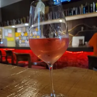 a glass of wine on a bar