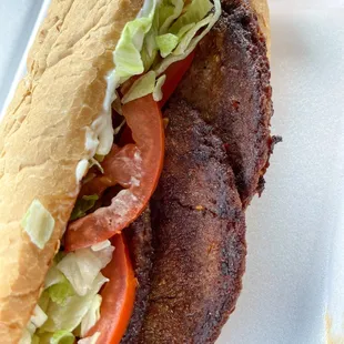 a sandwich with meat, lettuce, tomatoes, and lettuce