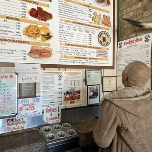 ows a man standing in front of a menu