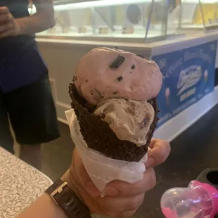 a hand holding a cone of ice cream