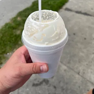 a hand holding a cup of ice cream