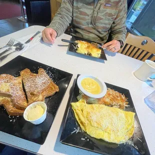 a man sitting at a table eating breakfast