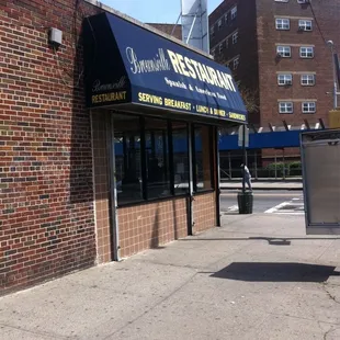 a brick building with a blue awning