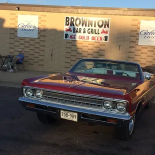 a red car parked in front of a brick building