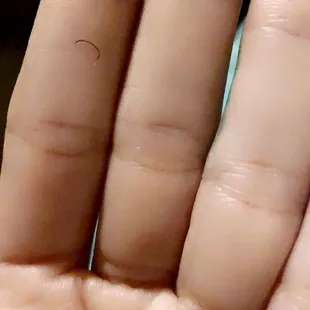 One of my eyelashes that fell out . Look how hard it was curled . Not a natural curl at all