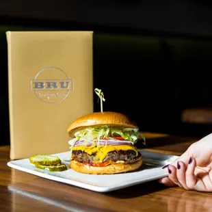 a person holding a plate with a burger on it