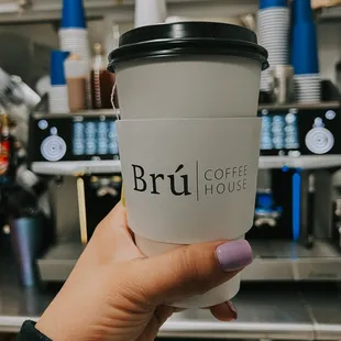 a hand holding a coffee cup