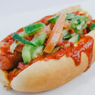 a hot dog with toppings on a bun