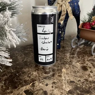 a can of beer next to a christmas tree
