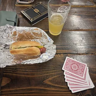 a hot dog and playing cards on a table