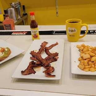 Our plates. Avocado toast with egg on top, bacon flight, hot chicken Benedict