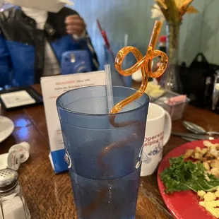 a glass of water with a straw and a pair of scissors sticking out of it