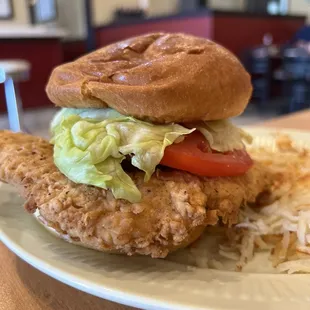 a fried chicken sandwich with lettuce and tomato