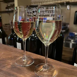 two glasses of wine on a bar