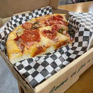 a slice of pepperoni pizza in a box