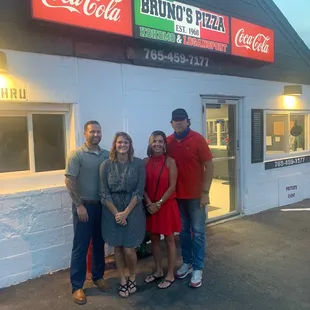 a group of people standing in front of a restaurant