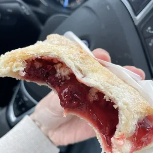a hand holding a half eaten pastry