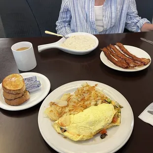 a woman sitting at a table with breakfast items