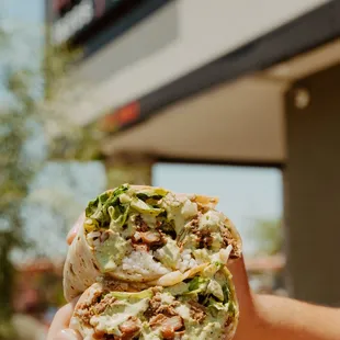 a hand holding a burrito