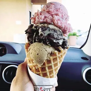 a hand holding a cone of ice cream