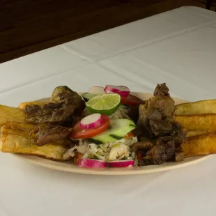 Yuca con Chicharron is a Great Appetizer, Fried Cassava (Yucca) served with Fried Pork Served on a Cabbage Salad (Curtido) bed!